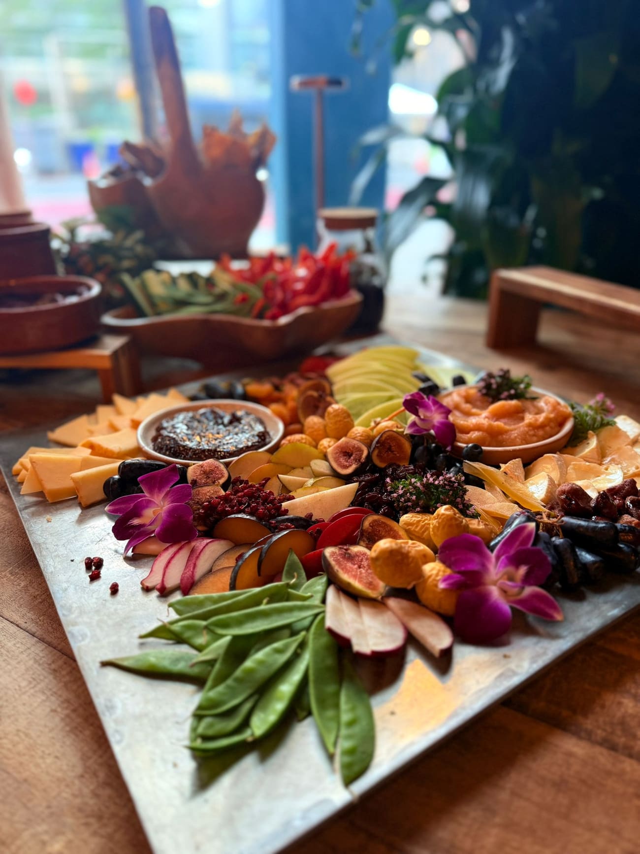 A grazing board in full bloom — cheeses, figs, edible flowers and fruit down the table