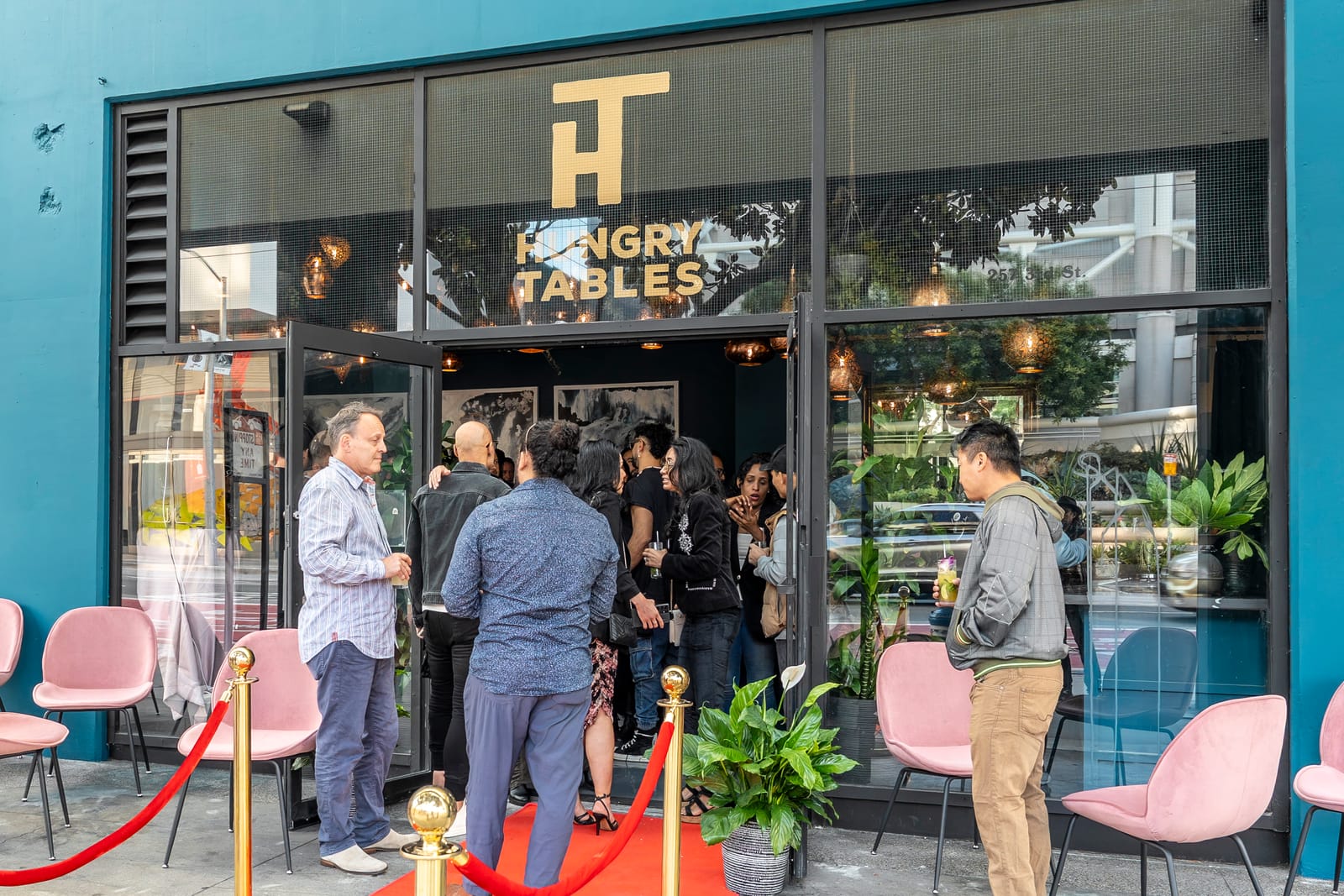 The Hungry Tables storefront on 3rd Street: black facade, gold HT monogram, red carpet at the door